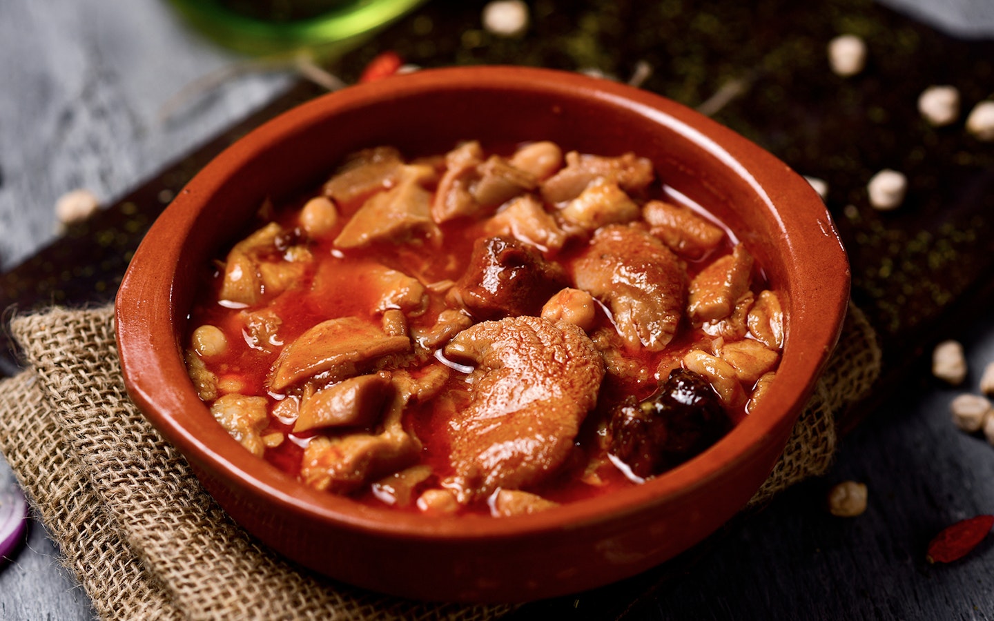 Traditional Spanish stew in a clay dish, part of a Flamenco and tapas tour in Triana.