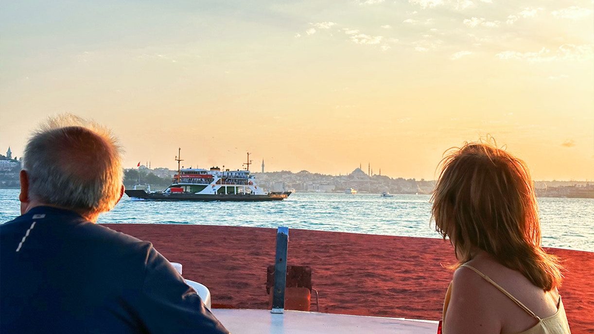 Guests enjoying the view of Bosphorus and Golden Horn during sunset yacht cruise in Istanbul.