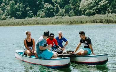 Canoe group on Bali's twin lake jungle trek with lush forest backdrop.