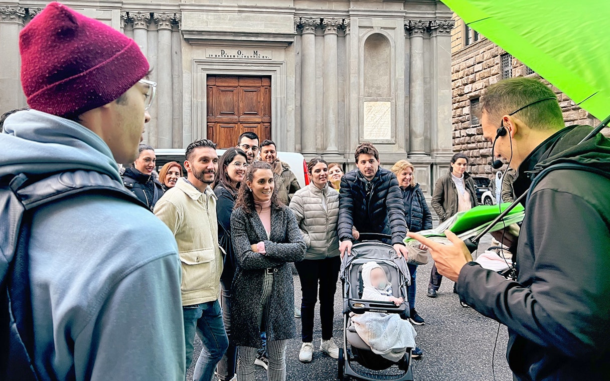 Tour group listening to a guide in Florence, Italy, during an essential walking tour.