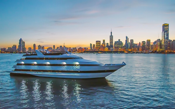 Cruise ship on Lake Michigan with Chicago skyline at sunset.