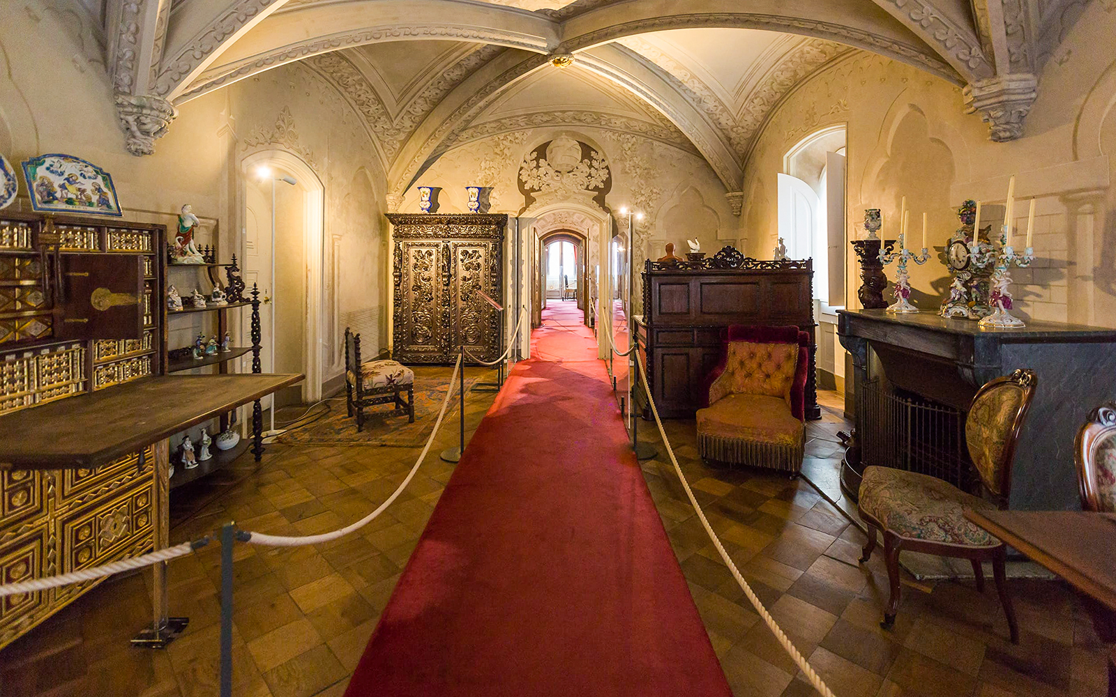 Interior of National Palace of Pena with ornate furniture and red carpet in Sintra, Portugal.
