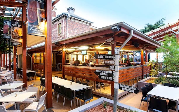 Outdoor dining area at riverside restaurant on Brisbane River lunch cruise.