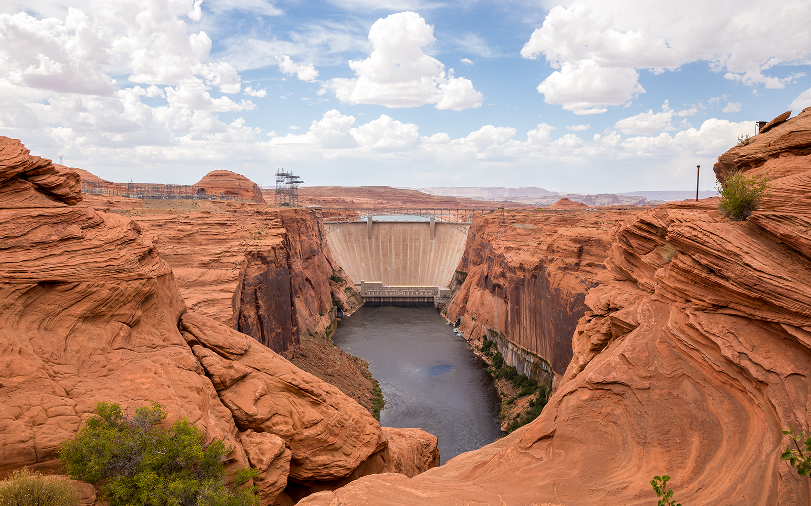 Glen Canyon Dam spanning the Colorado River, surrounded by red rock formations.