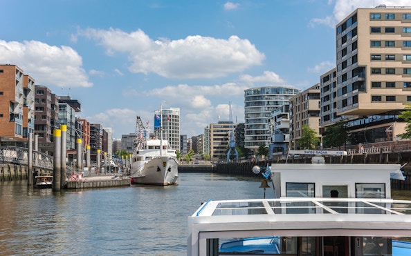Harbor view with boats and modern buildings during Hamburg harbor cruise.