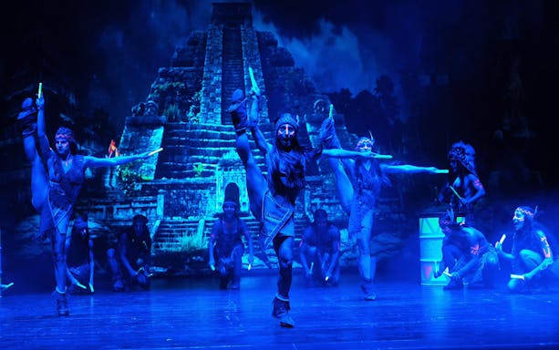 Performers in tribal costumes dancing on stage during Peter, El musical.