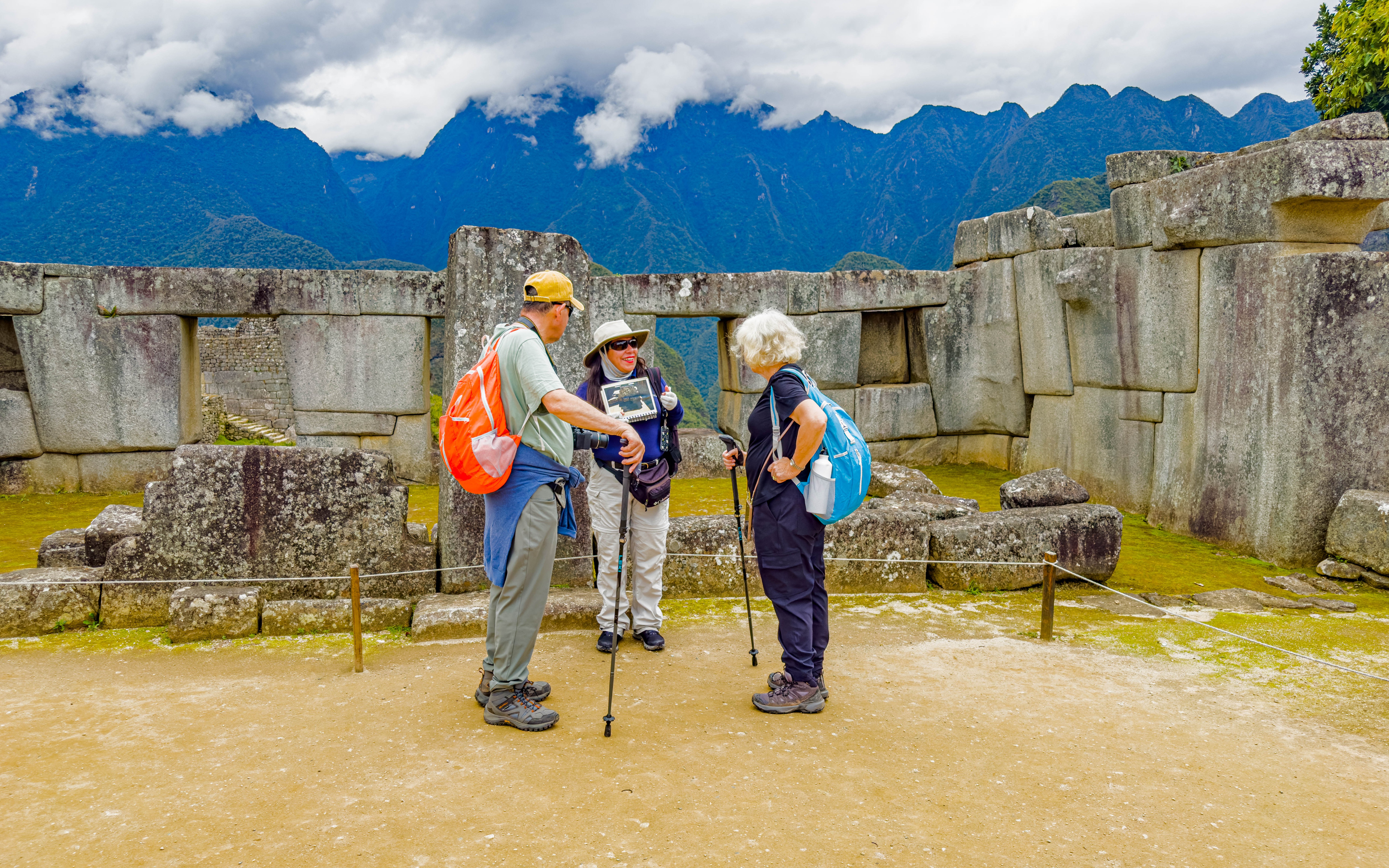 Guide with tourists at the Temple of the Three Windows, Machu Picchu, Peru.