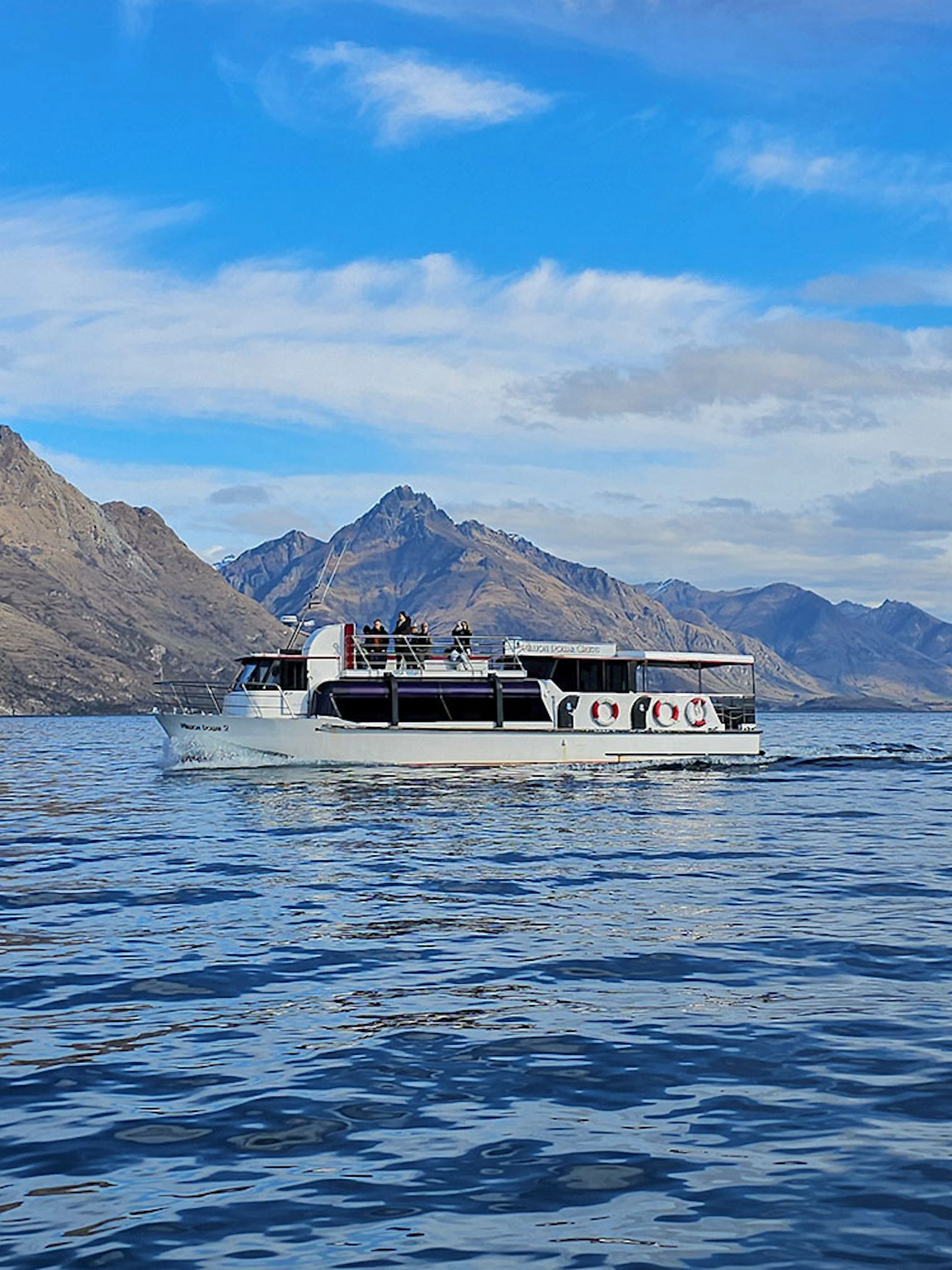 Cruise boat on Lake Wakatipu with mountain backdrop, Queenstown.