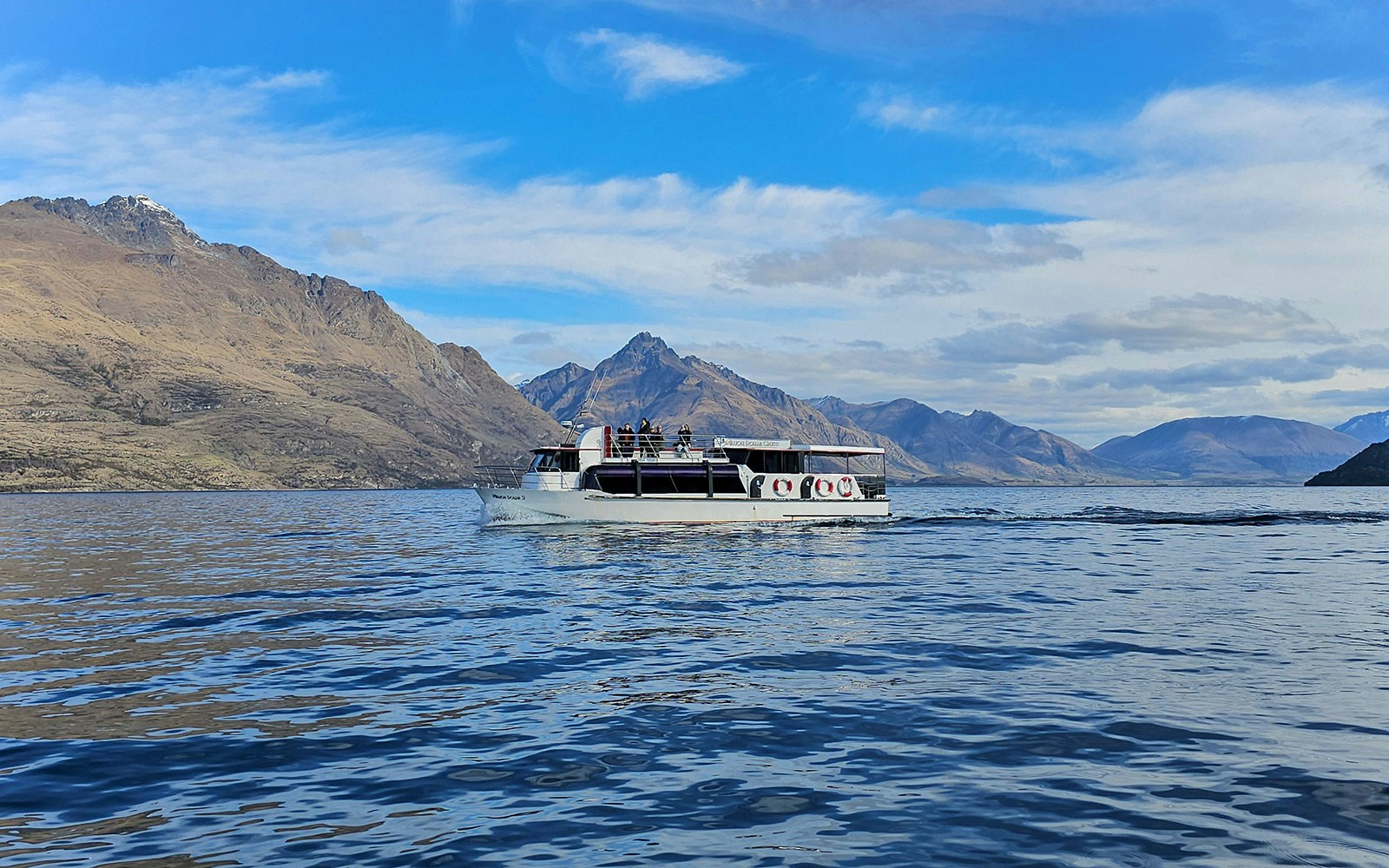 Cruise boat on Lake Wakatipu with mountain backdrop, Queenstown.