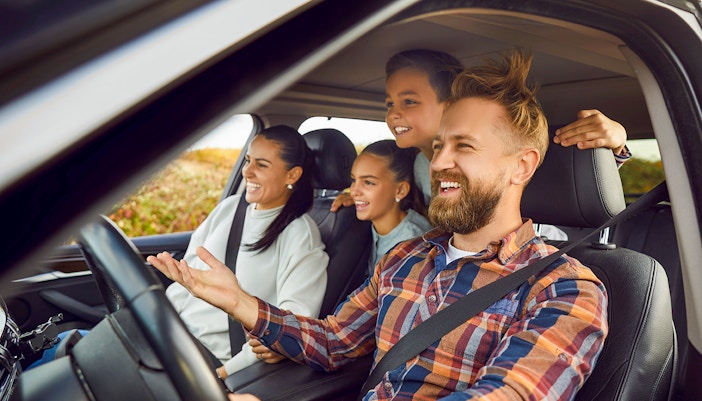 Family driving on scenic road trip through countryside
