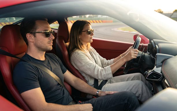 Woman driving a Ferrari 458 at Maranello Ferrari Museum track.