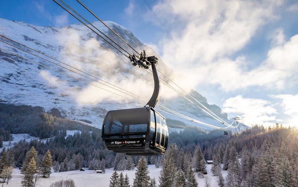 Eiger Express cable car ascending snowy mountain to Jungfraujoch, Switzerland.