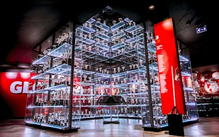 Benfica Stadium Museum trophy display with glass shelves and red backdrop.
