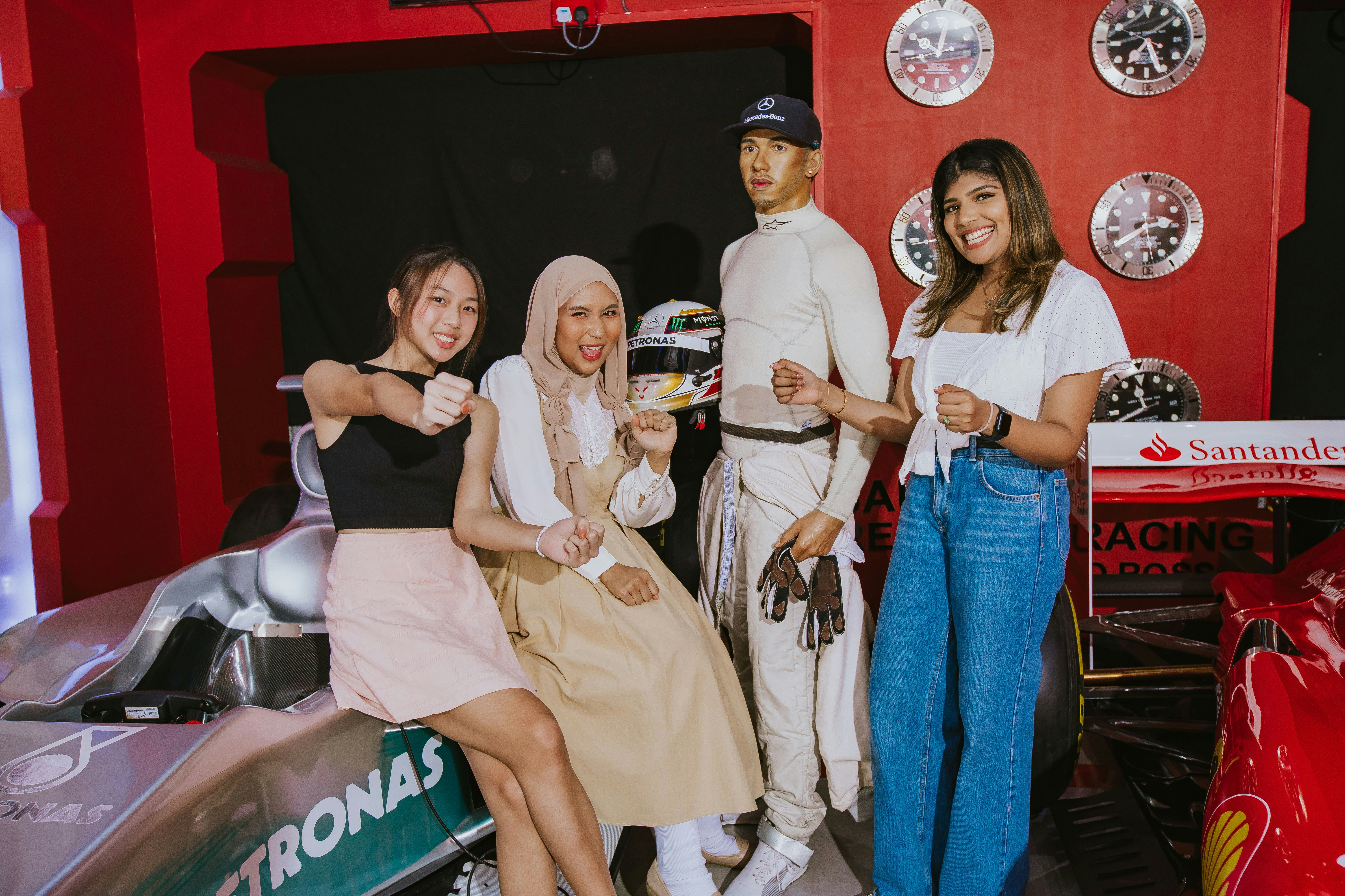 Wax figure of a race car driver with visitors at Madame Tussauds London.