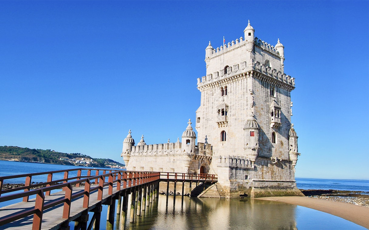 Belem Tower in Lisbon with wooden pathway over water.