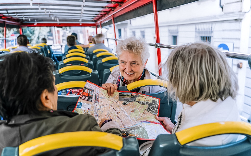 Tourists on a Naples hop-on hop-off bus discussing a map.