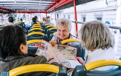 Tourists on a Naples hop-on hop-off bus discussing a map.