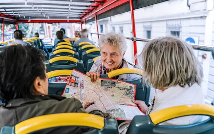 Tourists on a Naples hop-on hop-off bus discussing a map.