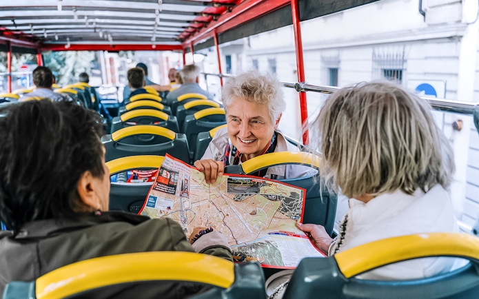 Tourists on a Naples hop-on hop-off bus discussing a map.