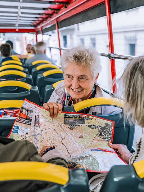 Tourists on a Naples hop-on hop-off bus discussing a map.