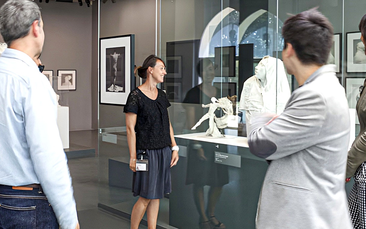 Guide explaining sculptures at Rodin Museum exhibit.