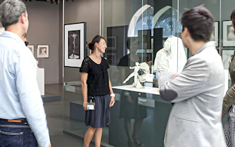 Guide explaining sculptures at Rodin Museum exhibit.