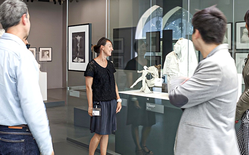 Guide explaining sculptures at Rodin Museum exhibit.