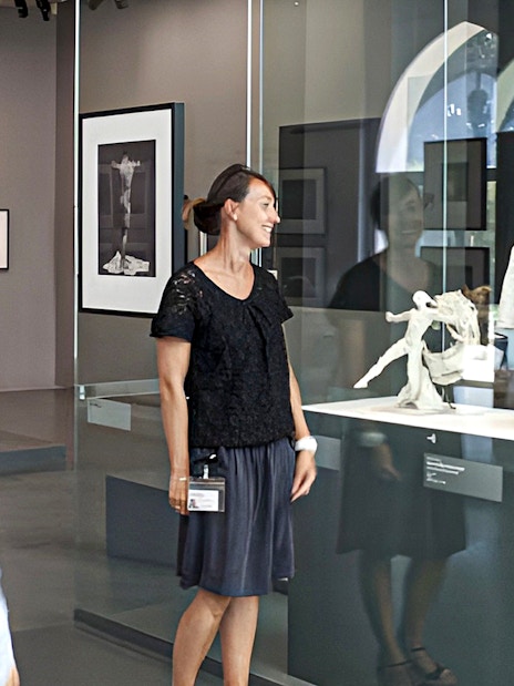 Guide explaining sculptures at Rodin Museum exhibit.