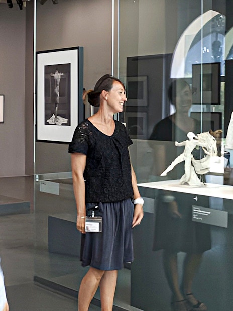 Guide explaining sculptures at Rodin Museum exhibit.