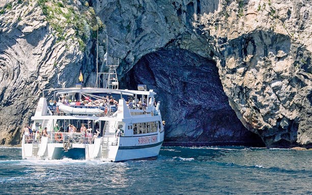 Boat approaching rocky cliffs on a trip to Cap Formentor and Cala Figuera.