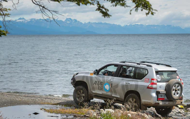 4x4 vehicle by Lake Fagnano during off-road tour in Tierra del Fuego, Argentina.