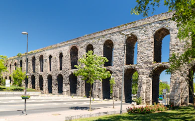 Aqueduct of Valens in Istanbul, Turkey with stone arches and surrounding greenery.