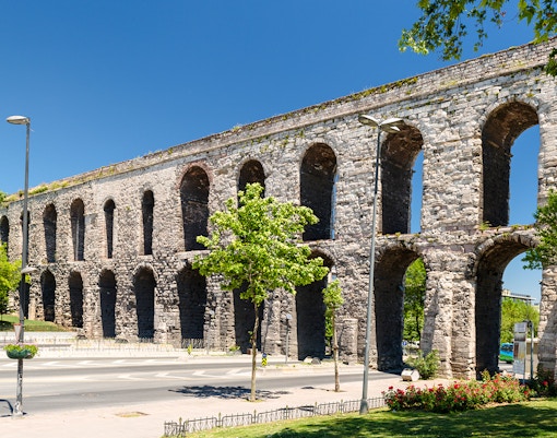 Aqueduct of Valens in Istanbul, Turkey with stone arches and surrounding greenery.