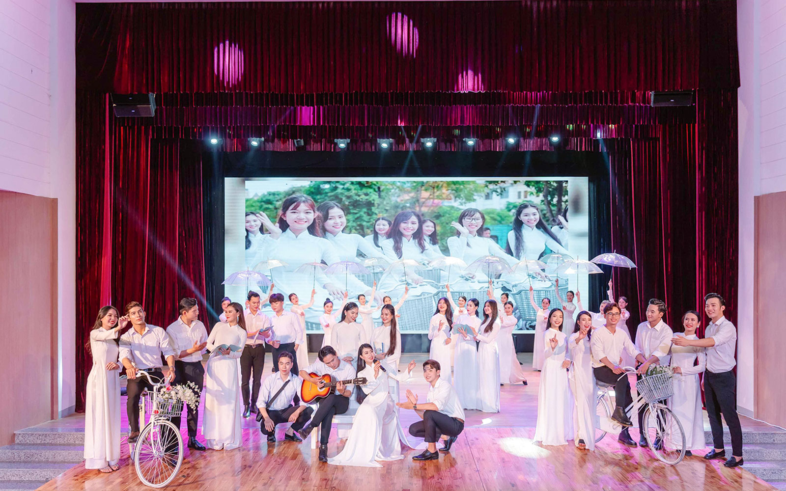 Performers in traditional Ao Dai costumes on stage during a show in Da Nang.