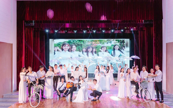 Performers in traditional Ao Dai costumes on stage during a show in Da Nang.