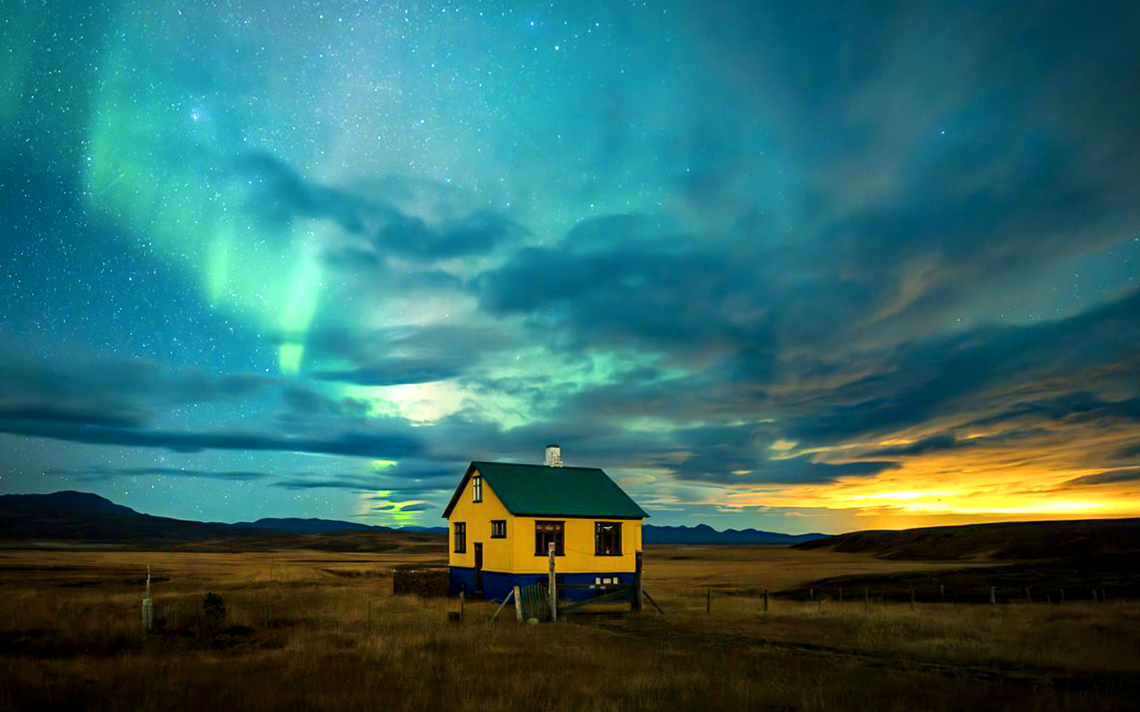 Northern lights over a rural house during Premium Northern Lights Super Jeep Tour.