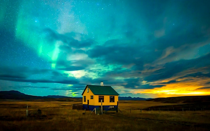 Northern lights over a rural house during Premium Northern Lights Super Jeep Tour.