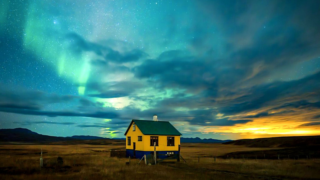 Northern lights over a rural house during Premium Northern Lights Super Jeep Tour.
