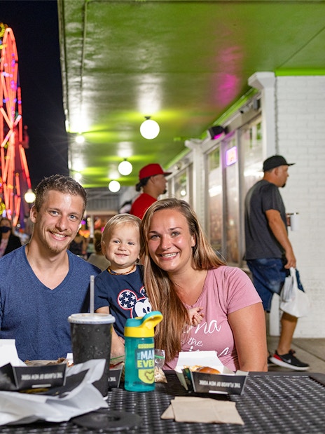 Guests dining at Old Town, Orlando with neon Ferris wheel in the background.