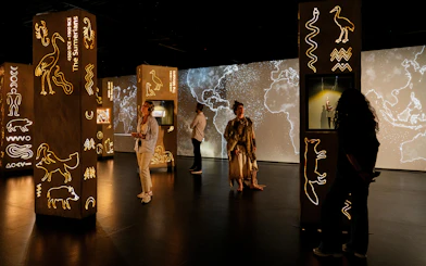 Visitors exploring illuminated ancient symbols at the London Timewalk Exhibition.