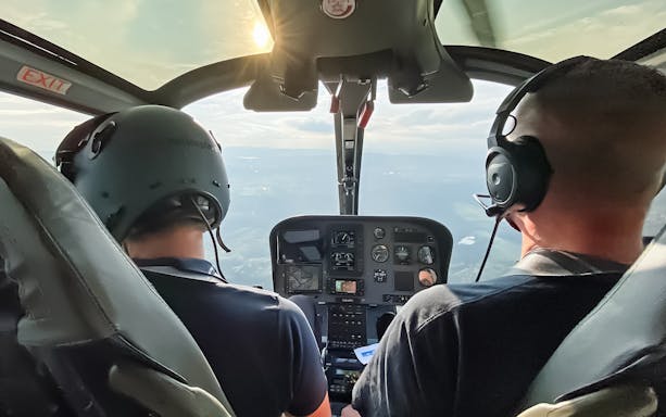 Helicopter cockpit view during scenic flight over Bernese Seeland and Jura.