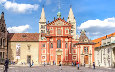 Basilica of St George exterior with tourists in Prague courtyard.