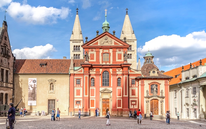 Basilica of St George exterior with tourists in Prague courtyard.
