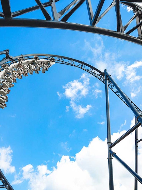 Roller coaster loop at Movie Park Germany against blue sky.