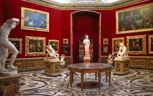 Tourists viewing sculptures and paintings in the Uffizi Gallery, Florence, Italy.