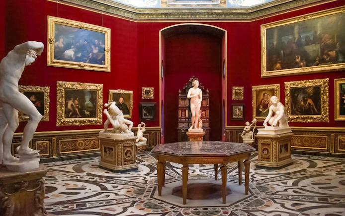 Tourists viewing sculptures and paintings in the Uffizi Gallery, Florence, Italy.