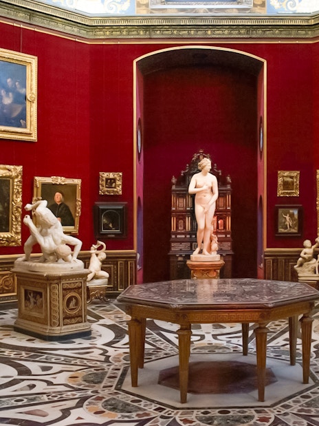Tourists viewing sculptures and paintings in the Uffizi Gallery, Florence, Italy.
