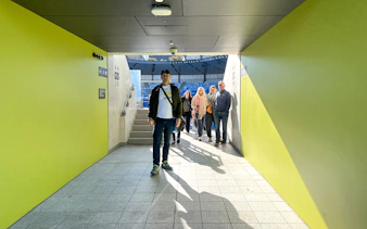 Group walking through Melbourne Park tennis stadium tunnel.