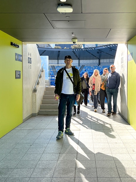 Group walking through Melbourne Park tennis stadium tunnel.