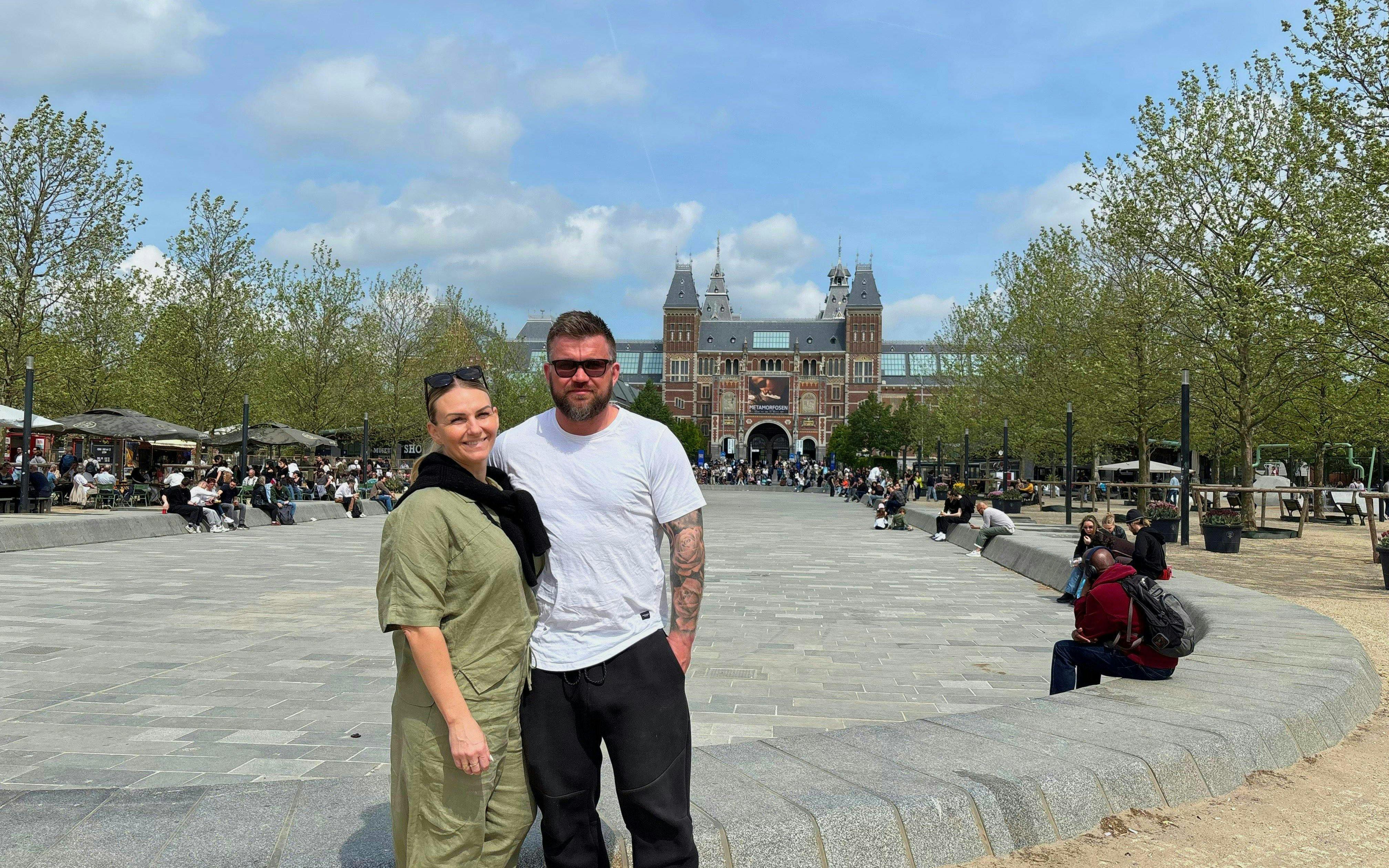 Couple standing in front of the Rijksmuseum, Amsterdam, during a bike tour city highlights.